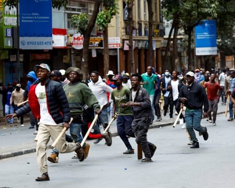 Pro-government counter-protesters run down the street with bats in their hands in downtown Nairobi, Kenya 17 June, 2025