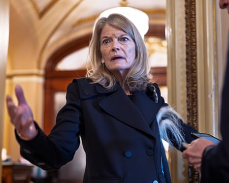 woman wearing black coat gestures while speaking