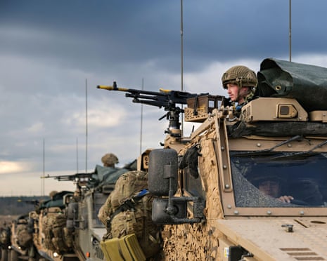 Armoured vehicles and soldiers pointing guns