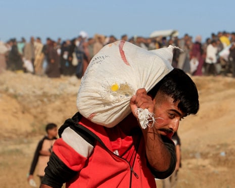 FILE PHOTO: A Palestinian walks near an aid distribution site in the southern Gaza Strip<br>FILE PHOTO: A Palestinian carries a sack as he and others gather to collect aid supplies from the U.S.-backed Gaza Humanitarian Foundation, in Khan Younis, in the southern Gaza Strip, May 29, 2025. REUTERS/Hatem Khaled/File Photo
